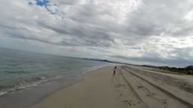 LOS CABOS MEXICO-2019: Child Playing on Beach Coastline with Stick