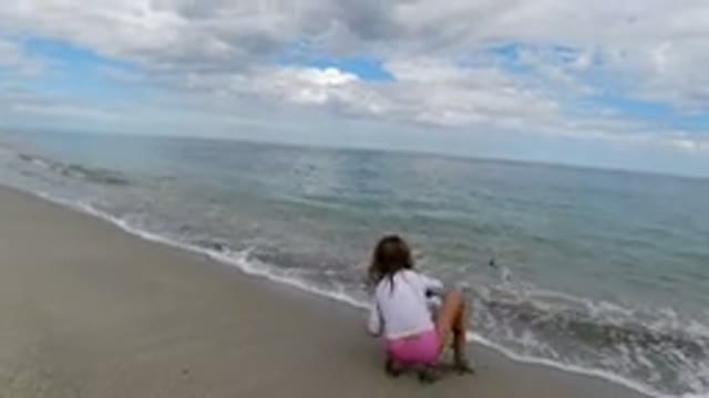 LOS CABOS MEXICO-2019: Girl in White Shirt on Beach Trying to Fish on Cloudy Day