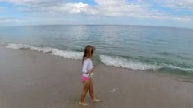 LOS CABOS MEXICO-2019: Little Girl With Walking Stick Walks Along The Side Of A Beach