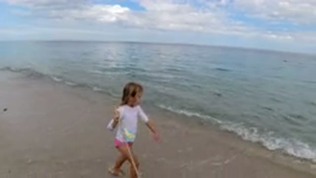 LOS CABOS MEXICO-2019: Girl Walking Down The Beach With A Walking Stick