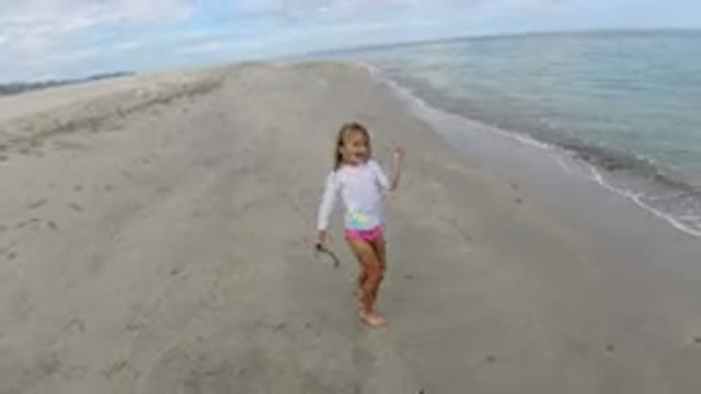 LOS CABOS MEXICO-2019: Small Girl Playing in the Beach with a Stick