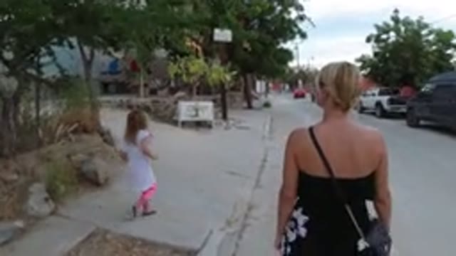 LOS CABOS MEXICO-2019: Woman And Child Walk Down Street And Observe The