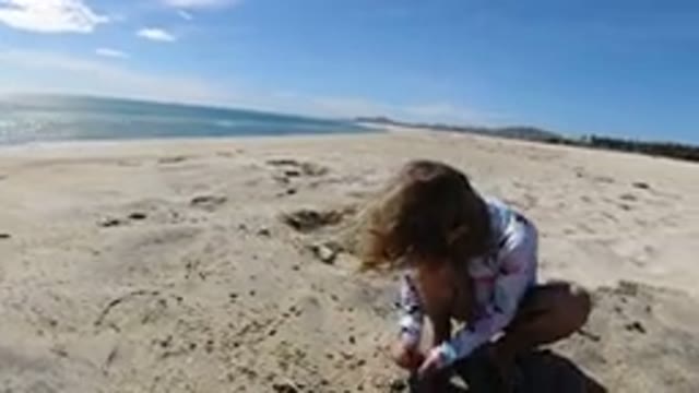 LOS CABOS MEXICO-2019: Blonde Child Playing With Sand By The Sea On Sunny Day