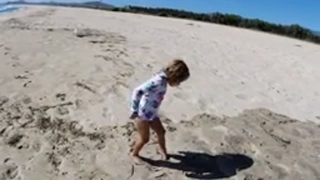LOS CABOS MEXICO-2019: A Young Girl in a Shirt and Swimsuit Plays on the Beach
