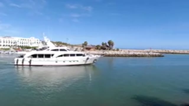 LOS CABOS MEXICO-2019: Sea With A Boat Passing By With A City Behind And The