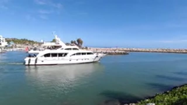 LOS CABOS MEXICO-2019: A Little Boy Watches A Yacht Move On The Water From Land