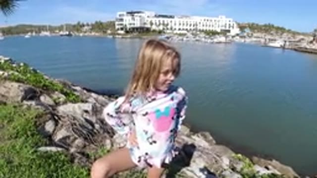 LOS CABOS MEXICO-2019: A Little Blond Girl Poses For A Photo On Rocks Beside A