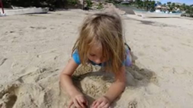 LOS CABOS MEXICO-2019: Blond Child in Blue Shirt Playing in Sand on Beach