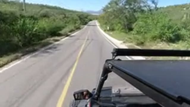 LOS CABOS MEXICO-2019: Jeep Traveling On The Road With An Old Man Alongside