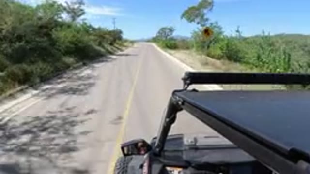 LOS CABOS MEXICO-2019: Highway Driving Curve Ahead Sign Scenic Lush Green Hills