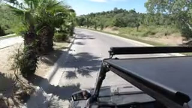 LOS CABOS MEXICO-2019: Black Golf-Cart Driving Fast Down An Empty Road On A