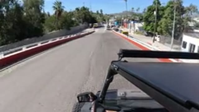 LOS CABOS MEXICO-2019: Black Jeep Drives Down a Sunny Street in Summer