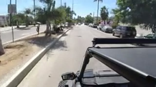 LOS CABOS MEXICO-2019: Vehicle Moves Along Divided City Street Past Buildings