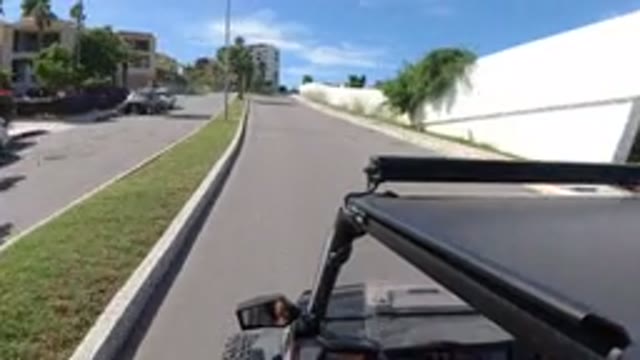 LOS CABOS MEXICO-2019: Vehicle Moves Down Divided City Street Past Buildings