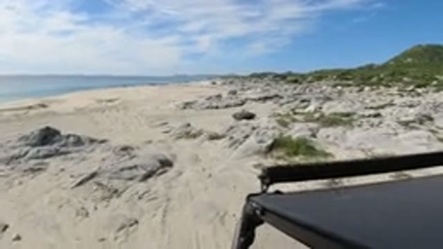 LOS CABOS MEXICO-2019: Vehicle Traverses A Beach With White Sand And Scrub
