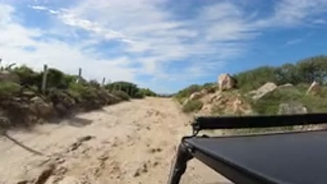 LOS CABOS MEXICO-2019: Black Car Driving Up A Sandy Road Towards The Beach