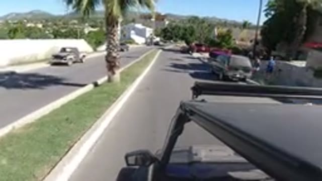 LOS CABOS MEXICO-2019: Driving In A Jeep On A Road With Palm Trees And White Buildings