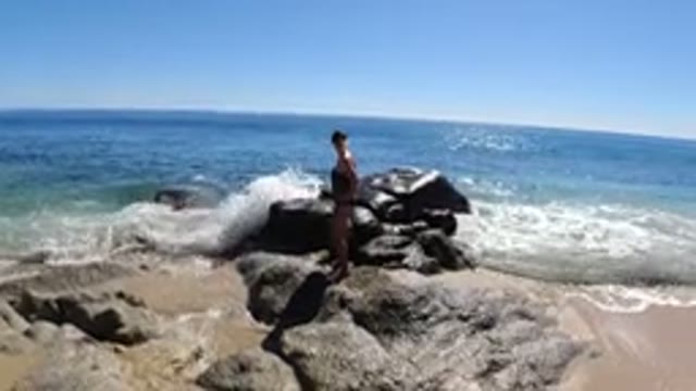 LOS CABOS MEXICO-2019: A Woman Standing On The Beach Rock And Enjoying Nature