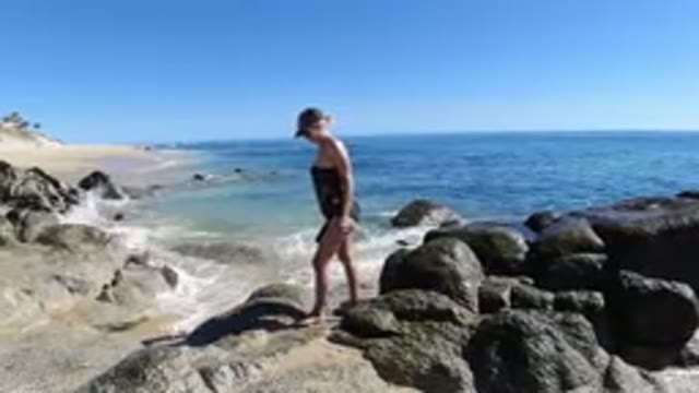 LOS CABOS MEXICO-2019: Woman In Bathing Suit Fully Walking Across Rocks