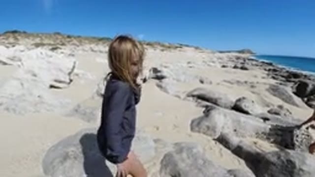 SAN JOSE DEL CABO MEXICO-2020: Two Blonde Girls At Beach Talk Near Rocks In