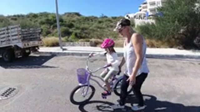SAN JOSE DEL CABO MEXICO-2020: A Woman Teaches A Child How To Ride A Bike By