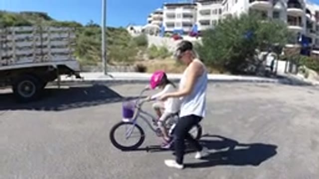 SAN JOSE DEL CABO MEXICO-2020: A Woman Teaching Cycling To Her Daughter In A