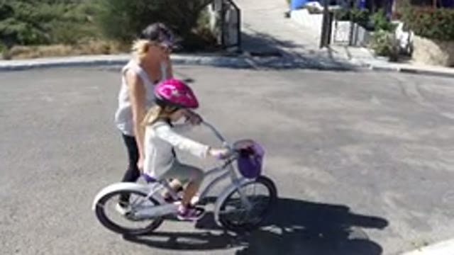 SAN JOSE DEL CABO MEXICO-2020: Mother Teaching Daughter to Ride Bike Helmet Street