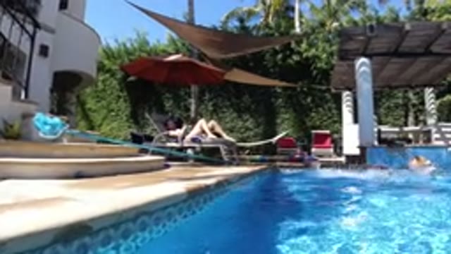 SAN JOSE DEL CABO MEXICO-2020: Dog Jumps In Swimming Pool With Child And