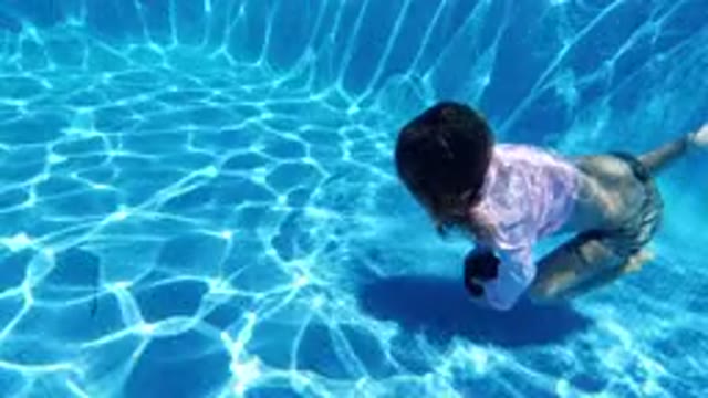SAN JOSE DEL CABO MEXICO-2020: Girl In Swimming Pool With Pink Shirt Picking Up Ball