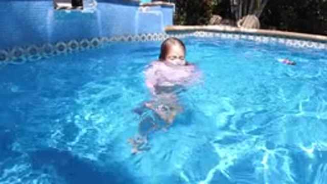 SAN JOSE DEL CABO MEXICO-2020: A Girl Kid Swimming Around In A Small Blue Pool