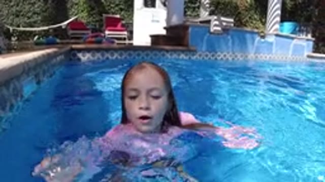 SAN JOSE DEL CABO MEXICO-2020: A Small Girl in a Dress Swimming with a Mermaid Doll