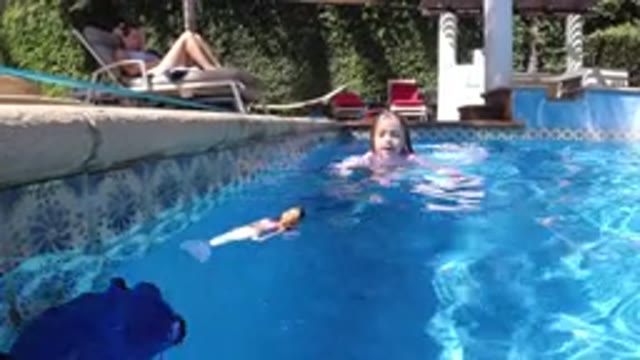 SAN JOSE DEL CABO MEXICO-2020: A Young Girl Swims In A Pool With A Doll That