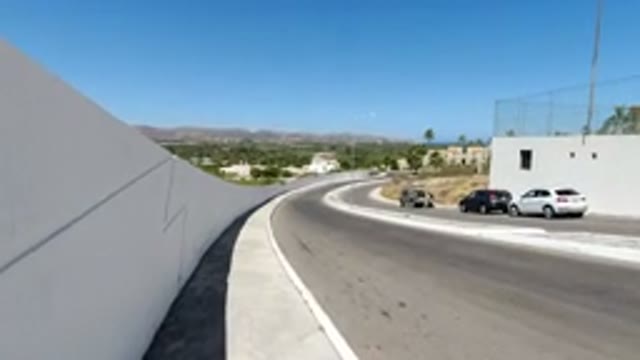 LOS CABOS MEXICO-2020: A Sidewalk View of a Highway and Parked Vehicles