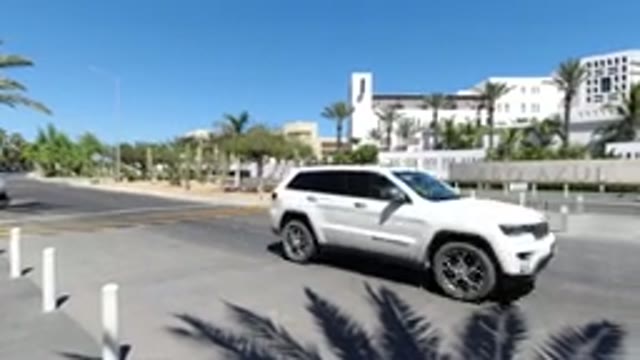 LOS CABOS MEXICO-2020: Car Drives By A Quiet Neighborhood With A Person Brushing