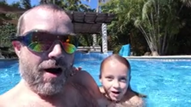 LOS CABOS MEXICO-2020: Man In Colorful Sunglasses Ducks Underwater In Pool With Child
