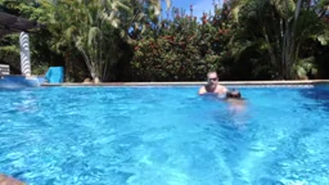 LOS CABOS MEXICO-2020: Man And Child Play In Pool On Sunny Day While Dog Watches
