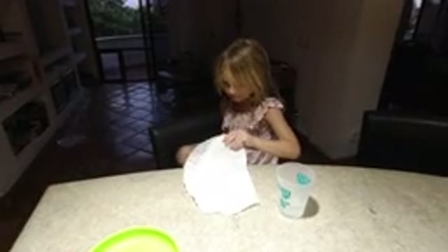 LOS CABOS MEXICO-2020: Young Girl Playing in Kitchen with Paper