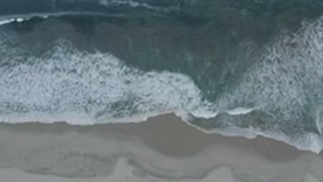 LOS CABOS MEXICO-2020: Flying Camera Captures Navy Blue Sea Waves Slowly Crashing