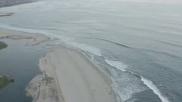 LOS CABOS MEXICO-2020: Flowing Blue Water with White Foaming Waves Near Brown Dry Shoreline
