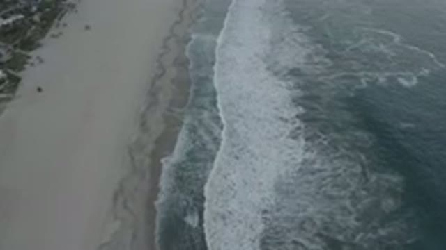 LOS CABOS MEXICO-2020: A Side Top View Of A Long Beach With White Bubble Waves