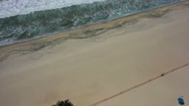 LOS CABOS MEXICO-2020: Blue Umbrellas On The Beach Zoom In Of Waves Crashing On
