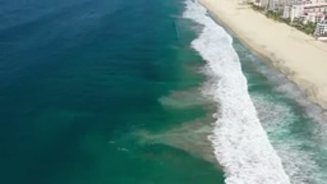 LOS CABOS MEXICO-2020: Beach View With Waves Showing Town Along Coast Line And