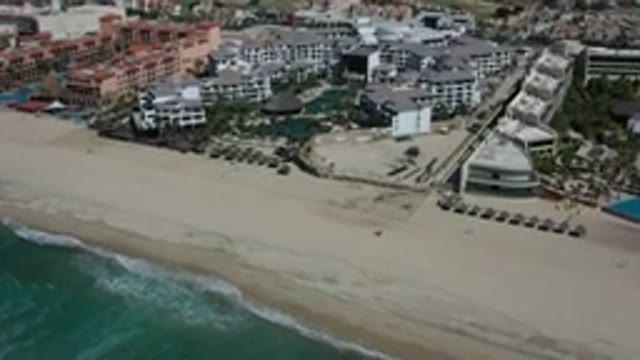 LOS CABOS MEXICO-2020: A Far Top View Of A Wide White Sand Beach And Buildings