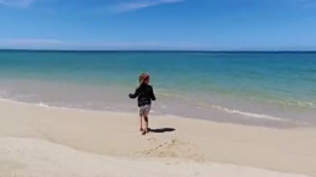 LOS CABOS MEXICO-2020: Child On The Beach Excited To See The Waves And Jump With