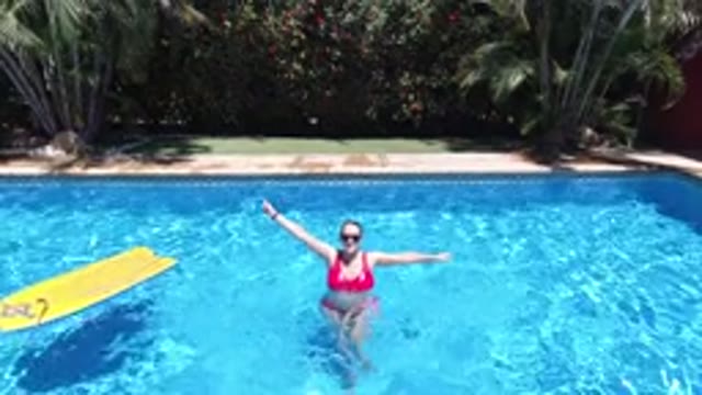 LOS CABOS MEXICO-2020: A Lady In Bikini In A Water Pool Waving Her Hand And A Dog Running Nearby