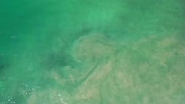 LOS CABOS MEXICO-2020: Blue Water With A Green Tint And Brown Dirt Rising
