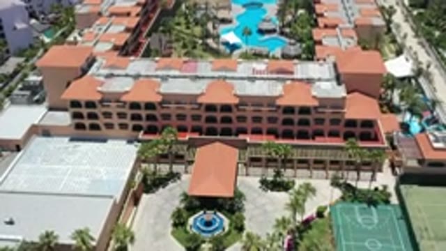 LOS CABOS MEXICO-2020: A View Of A Resort With Buildings Palm Trees And A