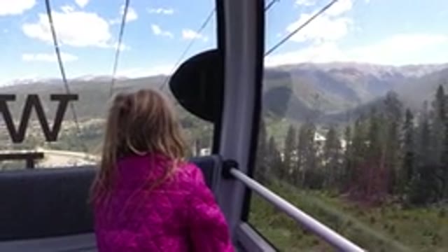 WINTER PARK COLORADO-2019: A Little Girl Is Riding In An Air Cab Overlooking The