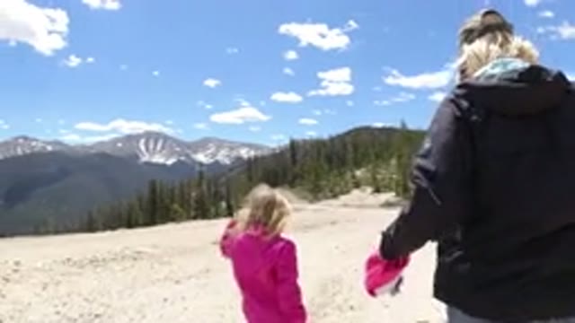 WINTER PARK COLORADO-2019: Blonde Lady And Little Girl In A Pink Coat Walking In