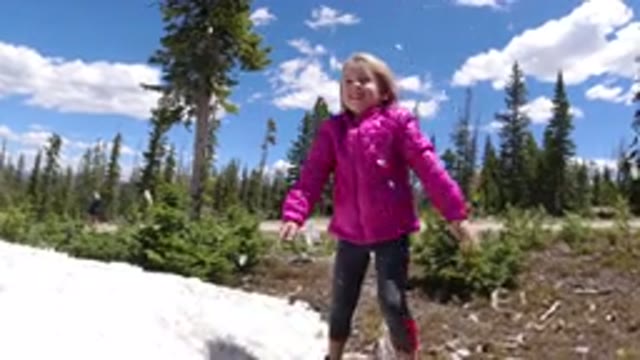 WINTER PARK COLORADO-2019: Little Blonde Girl Having Fun Throwing Snowballs
